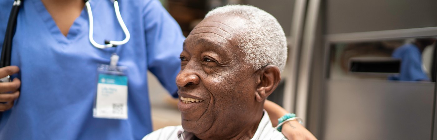 Black man over 70 sitting and smiling after leaving hospital