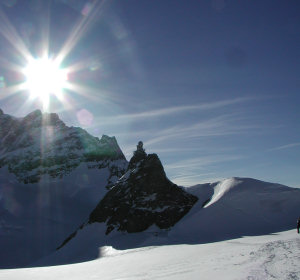 The sun over the Jungfrau mountain in early evening with the Sphinx laboratory visible in the foreground