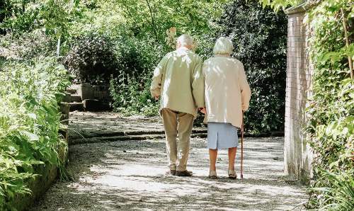 Elderly couple taking a walk through the park. Image courtesy of @micheile on Unsplash