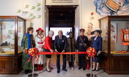 Group of people cutting a ribbon to open the gallery.