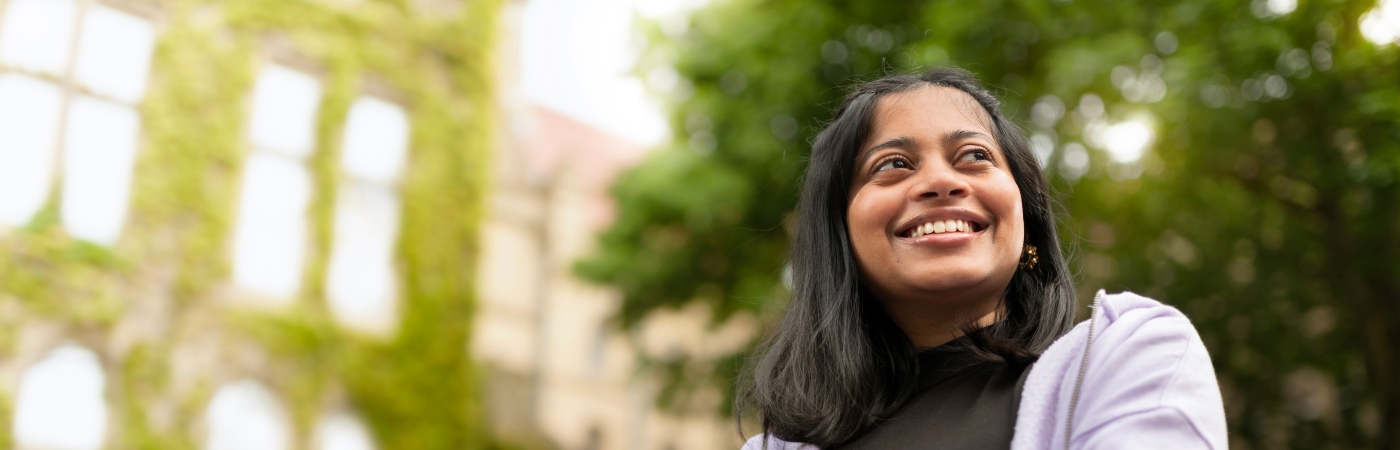 A smiling woman in front of the Beyer Building on campus.