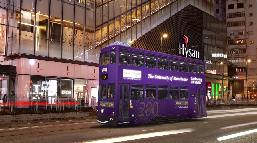 A University of Manchester light-up tram traverses the financial and heritage areas of Hong Kong Island.