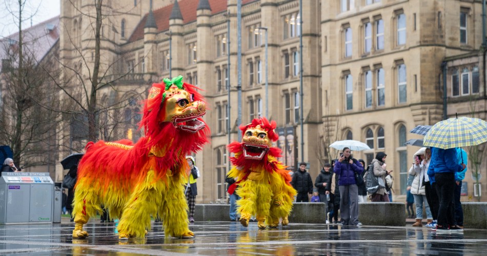 Two human-operated lions perform a Lion Dance near Whitworth Hall.