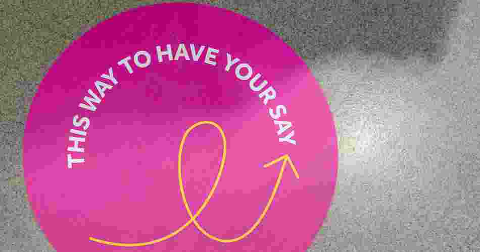 Wayfinding floor sign that reads 'this way to have your say'. 