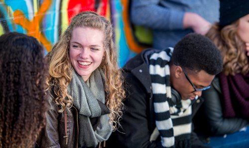 Blonde student talking to a fellow student