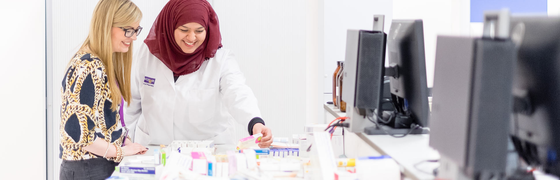 University students and tutors undertaking research in pharmacy lab 