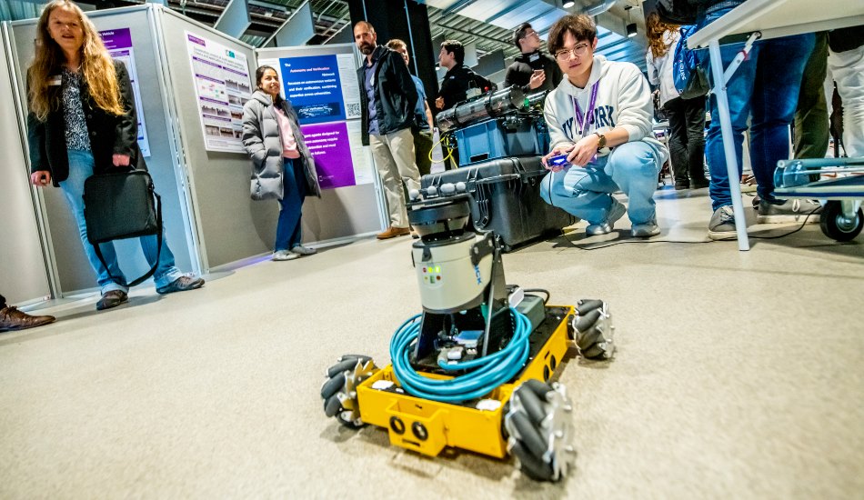 A student operates a small, wheeled robot