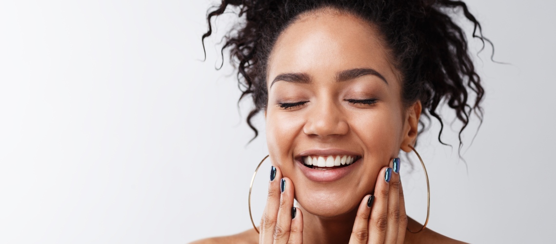 Woman smiling holding face
