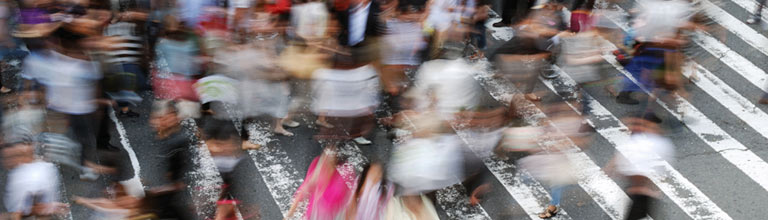 People blurred as they cross city street