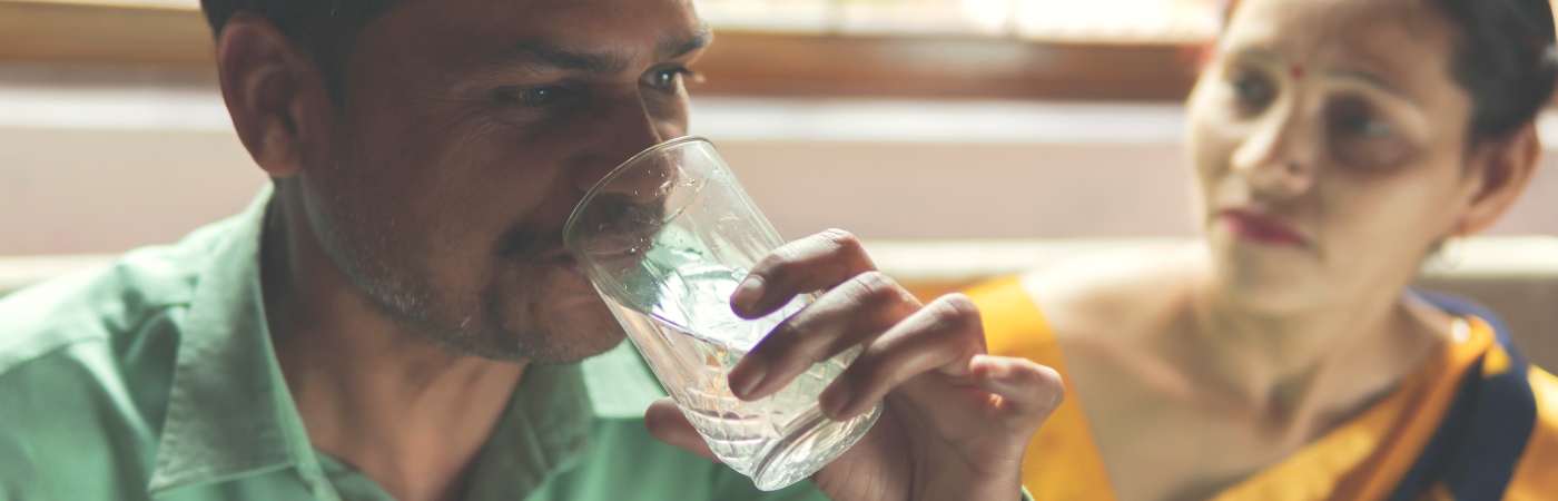 Indian man drinking glass of water