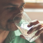 Indian man drinking a glass of water