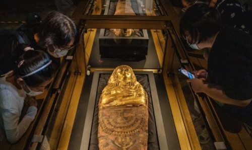 Guests looking at the Golden Mummies of Egypt exhibition at Manchester Museum.