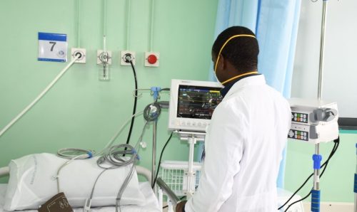 A Kenyan doctor looking at medical equipment.