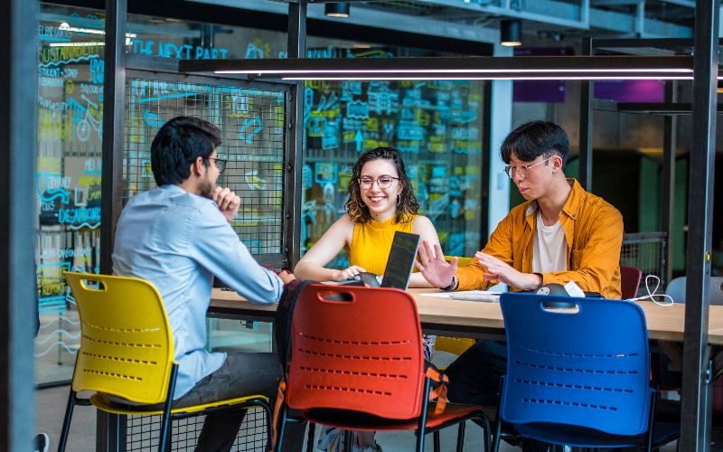 Three researchers sat at a table with laptops.