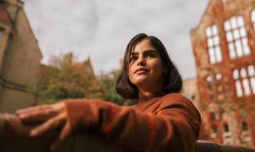Woman on bench outside historic building