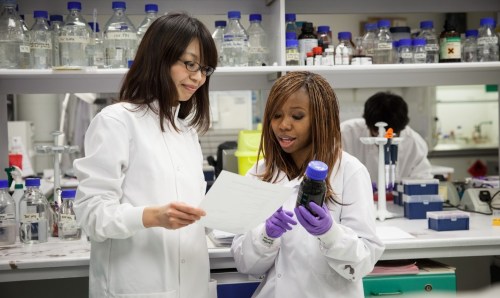 Two students in lab coats in a laboratory 