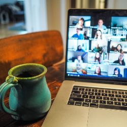 A mug sat next to a laptop with a Zoom call. 