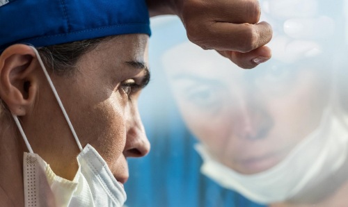 Male nurse with head against window