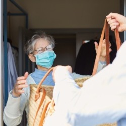 iStock image of shopping being delivered to an older person in a face mask.