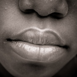 Black and white image of the bottom half a black person's face.
