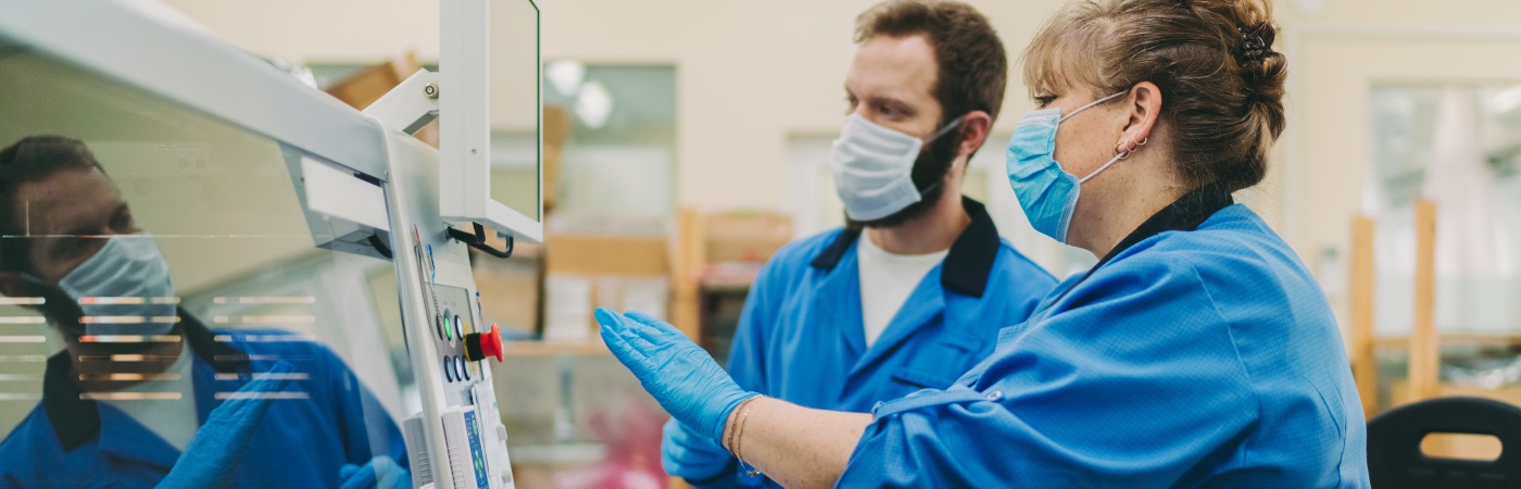 Two production factory workers wearing protective face-masks. Credit iStock/martin-dm