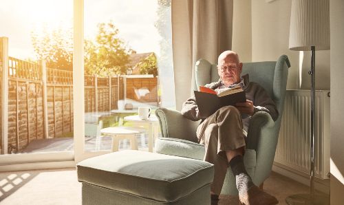 Elderly man reading in armchair