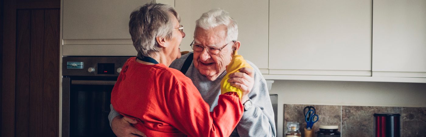 Older woman and man dancing in kitchen