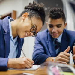 Teen students are working together and taking notes in lesson time at school.