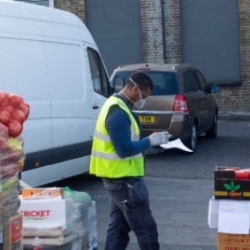 Key worker in high vis vest next to white van