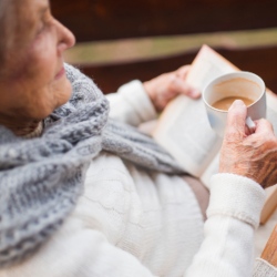 Older person drinking tea and reading