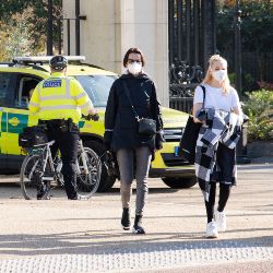women wearing masks, police officers on bikes and ambulance on Pall Mall during the coronavirus pandemic