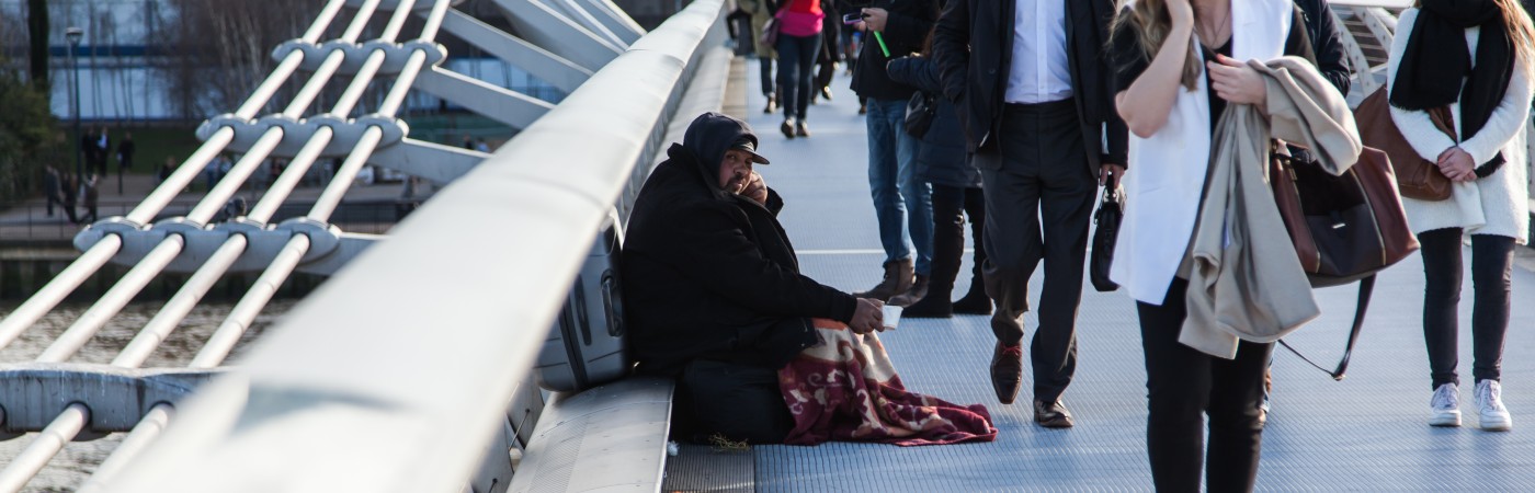 Homeless man on busy bridge. iStock/wcjohnston