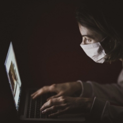 Student working on computer while wearing face mask