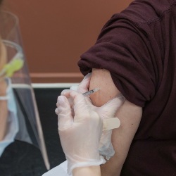 Patient receives Covid-19 vaccine shot. Photo by Steven Cornfield on Unsplash
