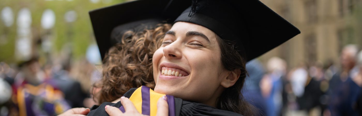 Alumni Helena and Daniella hugging on graduation day.