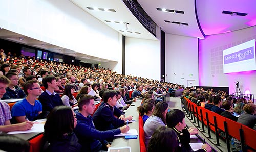 Students attending an even in a full lecture theatre