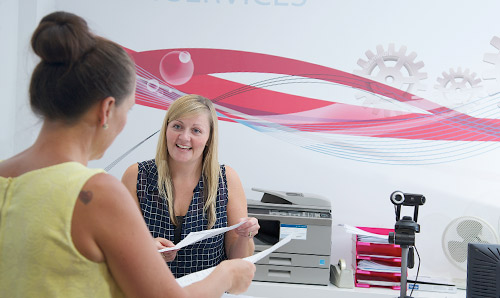 HR officer giving advice to colleague across HR help desk