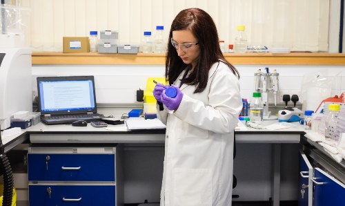 Scientist in lab labelling bottle