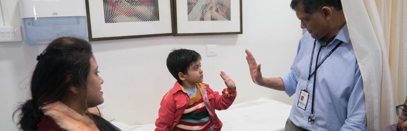 Professor Vaskar Saha high-fiving a child