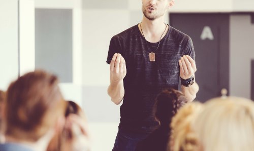 iStock image of a man in casual clothing talking to a group of students