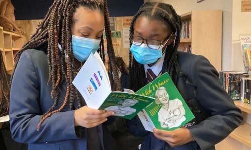 Image of two girls pointing to book