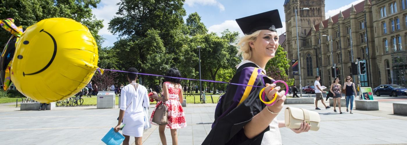 Female student at graduation holding a balloon