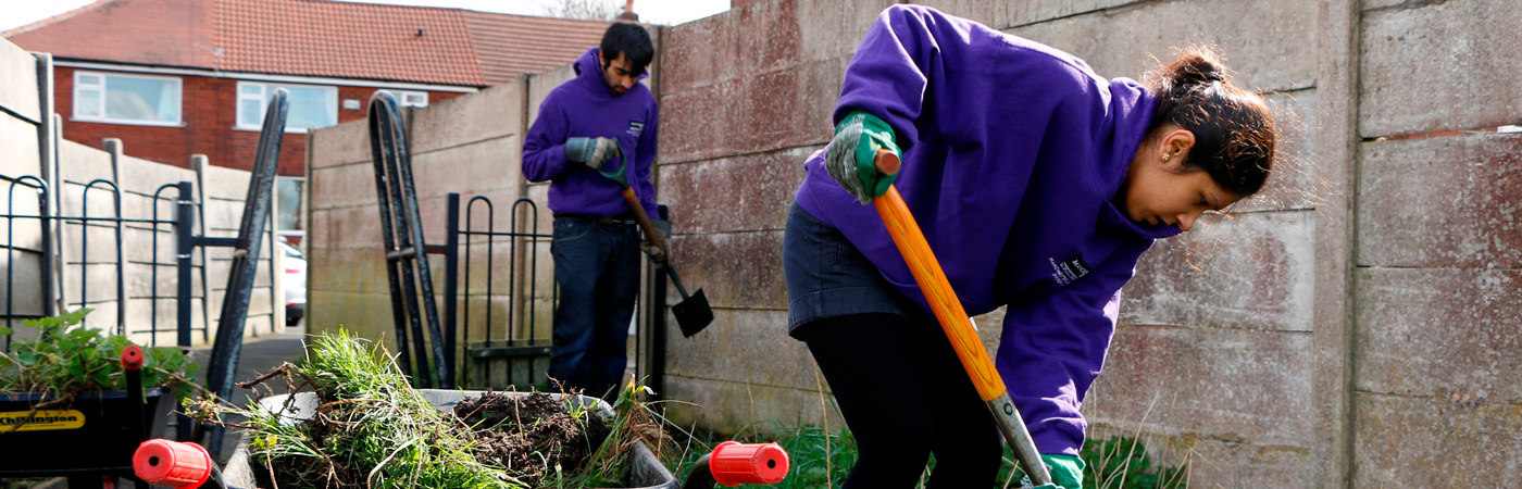 Two students digging a garden