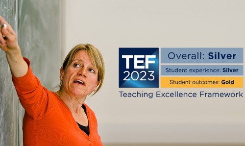 Lecturer pointing at board alongside TEF announcement.