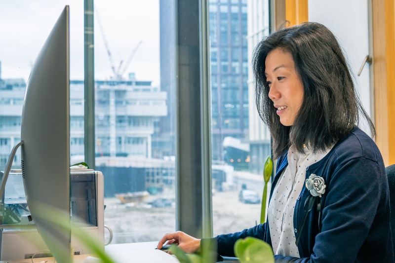 A member of staff working on a desktop computer in her office.