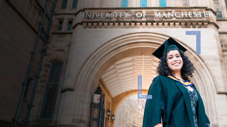 Student stood facing the camera and smiling, in the grounds of The University of Manchester. 
