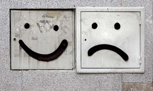 Graffiti faces (happy and sad) on square electrics boxes