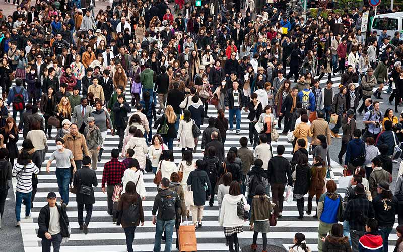 Large crowd crossing a busy pedestrian crossing, symbolising diversity, community, and urban life.