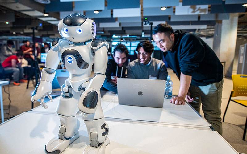 Students collaborating on a humanoid robot project, symbolising AI research, tech, and innovation.