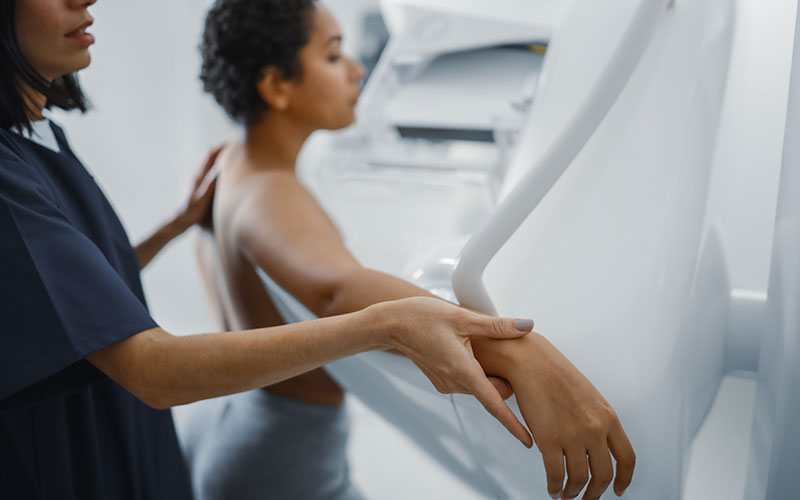 Healthcare worker assisting a patient with medical imaging, symbolising research and innovation.